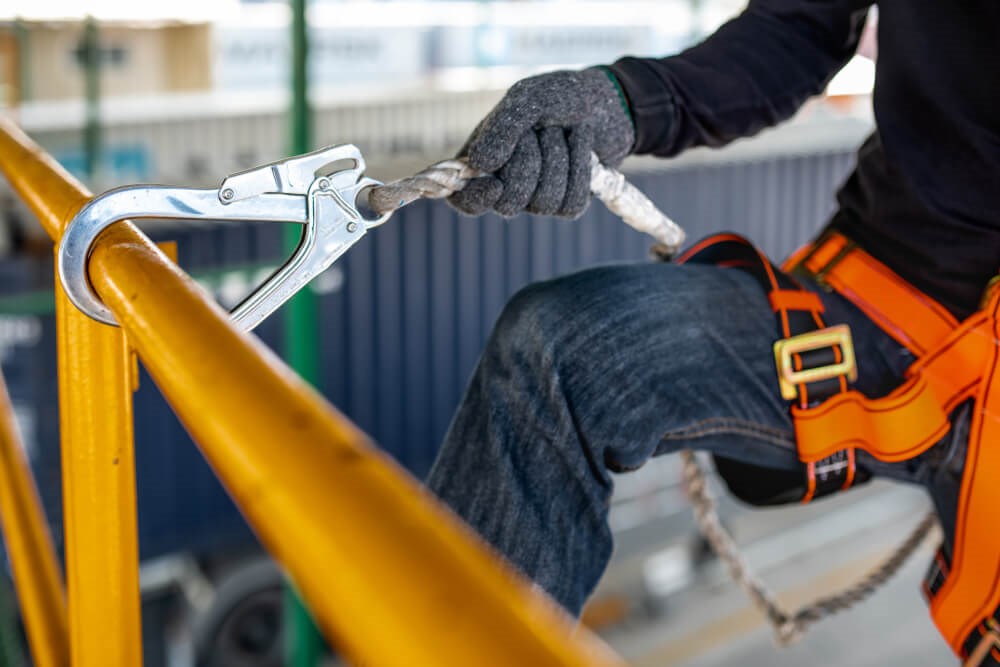 An employee wearing a harness to prevent falls from heights on a scissor lift